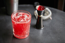 Roter Cocktail in einem Glas mit Eiswürfeln