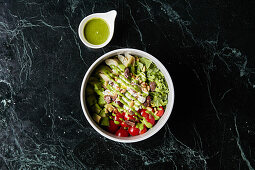 Gesunde Bowl mit Avocado, Tomate, Artischocke und Oliven