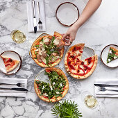 Different types of pizzas sliced on a marble table