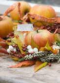 Small wreath made of rosehips, snowberries, vinegar tree leaves and heather, with apple and name tag