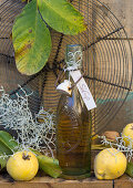 Quince syrup with a label and a cake rack with quinces and walnut leaves