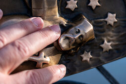 Frau berührt eine bronzenes Relief des Hl. Johannes von Nepomuk auf der Karlsbrücke, Prag, Tschechien