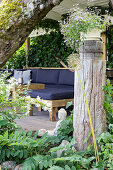 Overgrown wooden terrace with an patio sofa