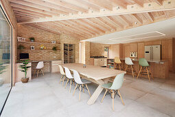 Modern open-plan living room with wooden beamed ceiling and brick wall