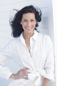 Mature dark-haired woman in white dress with embroidery