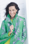 Mature, dark-haired woman in a green coat