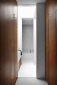 Wardrobe with floor-to-ceiling fixtures, view into the bathroom