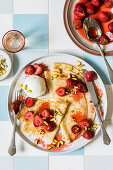 Thin crepes with honey roasted strawberries compote, pistachios and a scoop of cream cheese