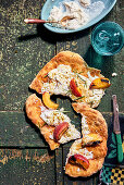 Pinsa with grilled peach, ricotta, pistachios and rosemary