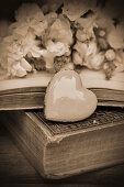 A decorative heart on a book with flowers