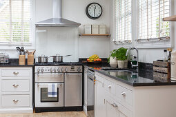 L-shaped kitchen with light cabinet fronts, window with blinds