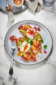 Poached eggs with avocado and tomatoes on brioche bread
