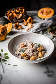 Pumpkin gnocchi with chanterelles, olive oil, and parmesan cheese