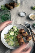 Meatballs on skewers with cucumber salad