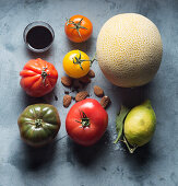 Ingredients for vegan tomato salad with honeydew melon and almonds