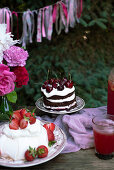 Pavlova mit Erdbeeren und Schwarzwälder Kirschtorte mit Süßkirschen
