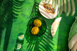 Zitronen und Galiamelone auf grünem Untergrund
