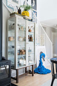 Display cabinet with tableware and blue sculptural in an open living space