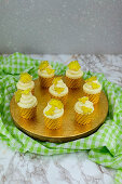 Honig-Kirsch-Cupcakes auf goldener Servierplatte