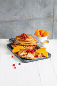 Buckwheat pancakes with clementines, pomegranate seeds and almond cream