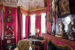 Desk at window with red velvet and gilding