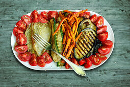 Grilled vegetables on a serving platter on a wooden surface