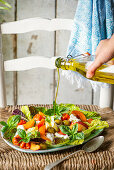 Sommersalat mit frischen Aprikosen, Mozzarella, Oliven, gerösteten Tomaten und Basilikum