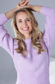 Blonde Frau im lila Pullover