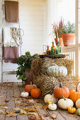 Strohballen und Kürbisse auf herbstlicher Veranda