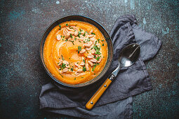 Cream of pumpkin soup sprinkled with peanuts in ceramic bowl