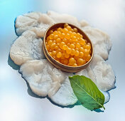 Fish roe in metal bowl on fish carpaccio