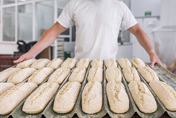 Gebackene Brotlaibe in Backformen in einer Bäckerei