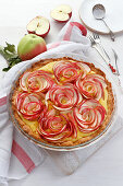 Tart on shortcrust pastry with apple slices arranged in flowers