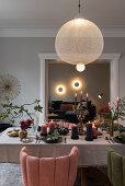 Festively laid Christmas table with upholstered chairs, view into the living room