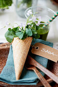Waffle cone filled with wood sorrel on place setting