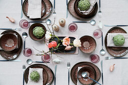 Set table decorated with poppy blossoms and artichokes