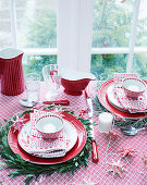Table set with red and white crockery and decorated for Christmas
