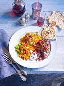 Moroccan lamb shoulder with sticky pomegranate glaze, vegetables and pita bread