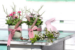 Bouquet of bellis with Easter decoration in green containers