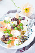 Melon and mozzarella salad with chili peppers and herbs