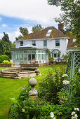 View from rose bed to lawn with pond and to residential house