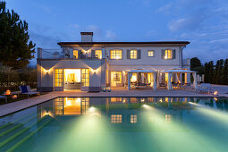 An illuminated villa with a pool