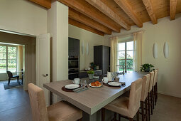 A kitchen counter with an adjacent breakfast table and upholstered chairs