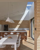 A modern, light-flooded kitchen and dining area