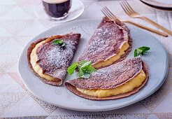 Chocolate pancakes with cream and verbena