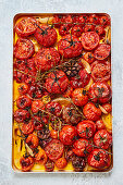 Preparing roasted tomato sauce - Tomatoes with garlic and herbs on an oven tray