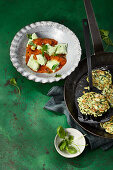 Green gnocchi with zucchini pancakes on roasted tomato sauce