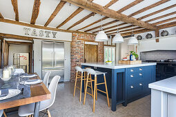 Dining area and center kitchen island in open plan kitchen with wooden beam ceiling