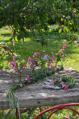 Tischdeko mit Tränendem Herz (Dicentra Spectabilis) und Storchschnabel (Geranium macrorrhizum), Kranz binden