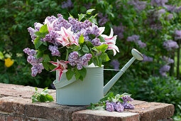 Bouquet of tulips (Tulipa) and lilac flowers (Syringa) in old watering can